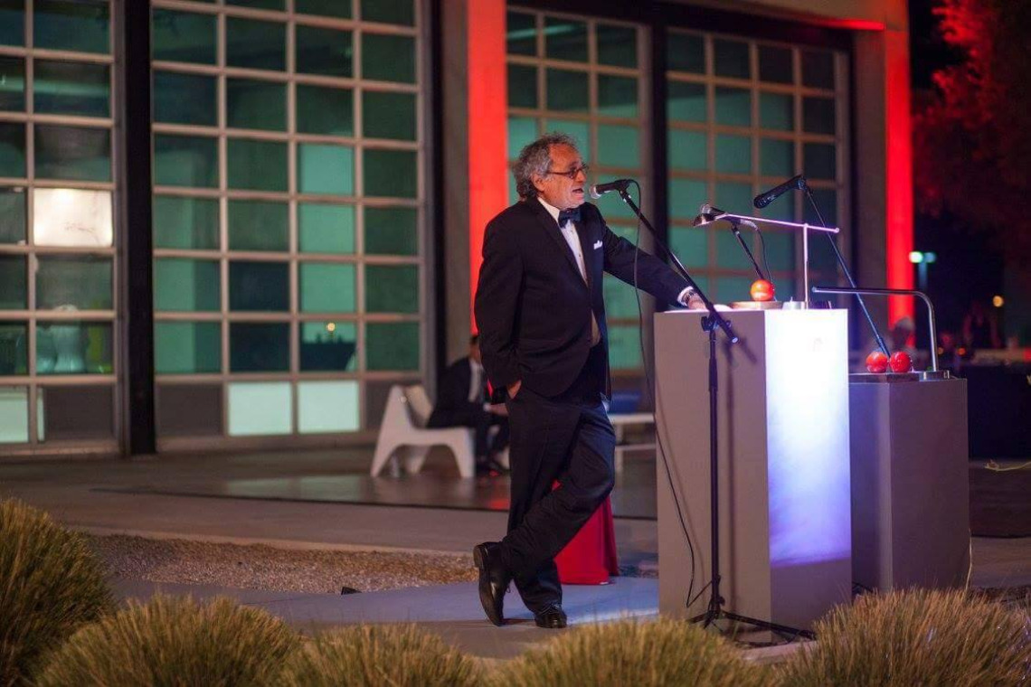 man standing at a podium outdoors at night
