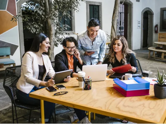 group of students at table looking at laptop