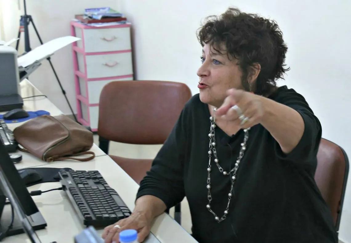 woman sitting at a desk pointing off to the side