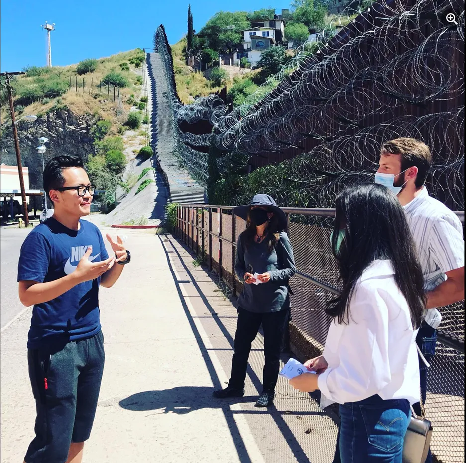 Syrym Itkulov with journalists in front of border wall