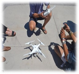 three students learning how to fly a drone