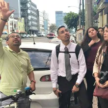 man pointing up as three other people look up in that direction