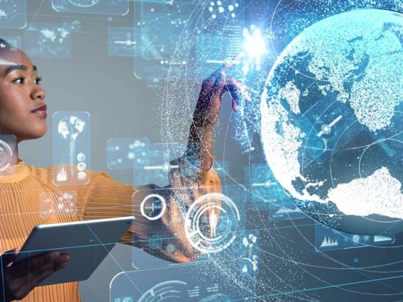 woman holding a tablet tapping digital image of the world