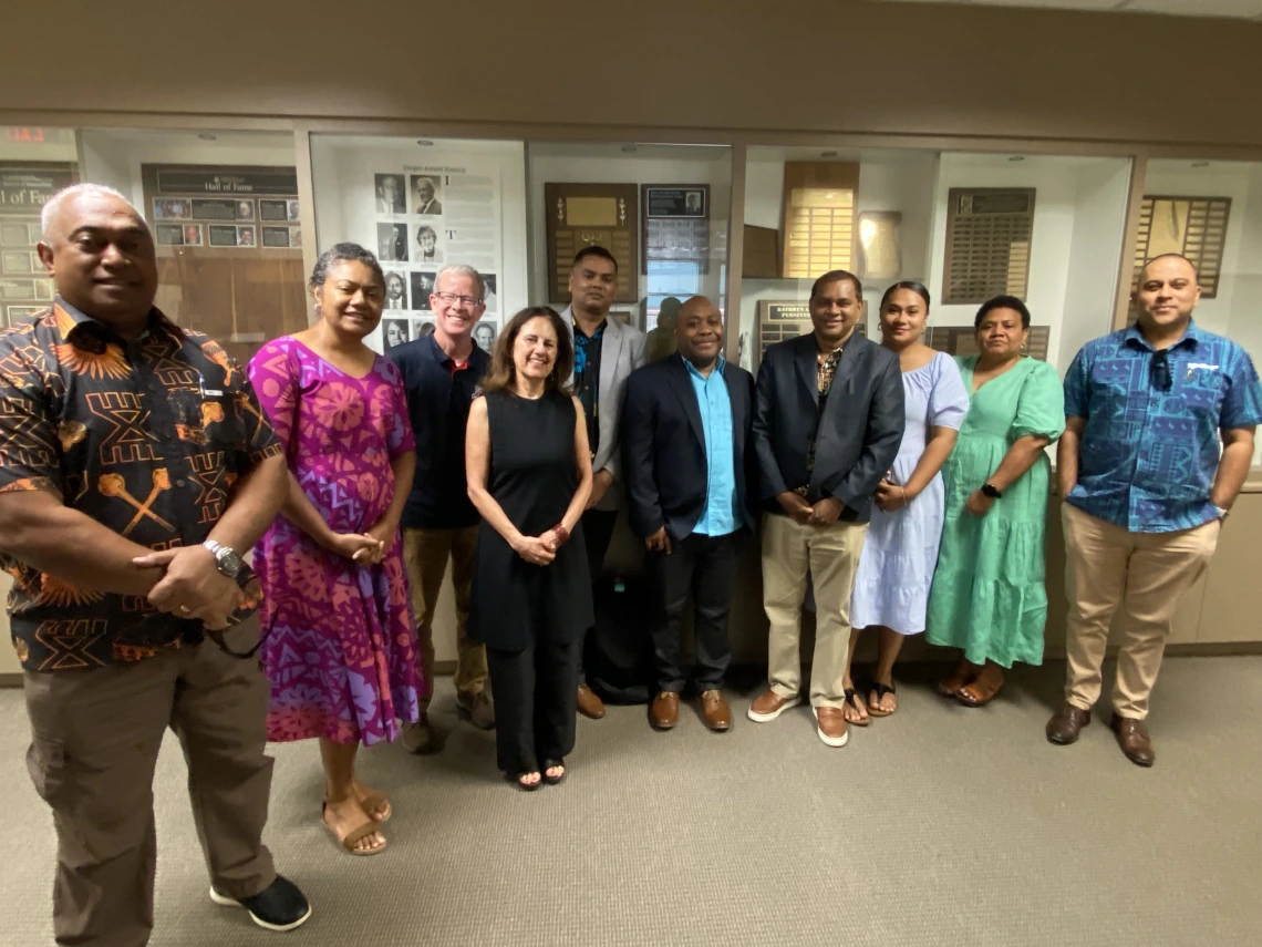 A group of journalists stand together in the halls of the School of Journalism