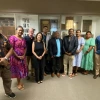 A group of journalists stand together in the halls of the School of Journalism
